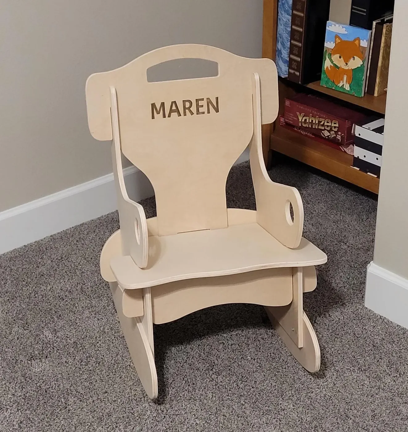 Personalized wooden rocking chair with a name engraved on the back