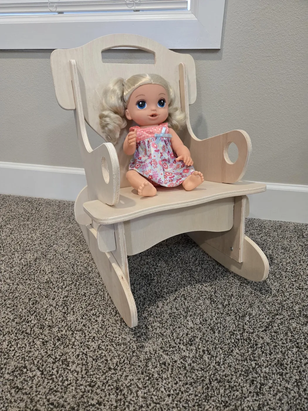 Small wooden toddler rocking chair with a doll seated in it